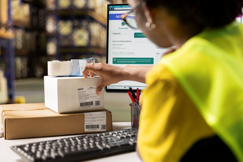 Carrito de compras con una caja sobre una laptop que simboliza las compras en línea y los envíos de productos adquiridos en plataformas de comercio electrónico como Amazon.
