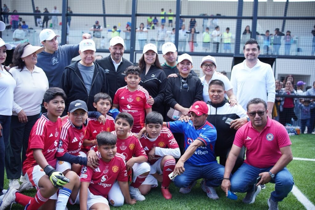 Autoridades estatales, deportistas y niños integrantes de un equipo de futbol posan para una fotografía durante la inauguración de la Ciudad Deportiva de Alto Rendimiento de Hidalgo, en una de las nuevas canchas del complejo deportivo.