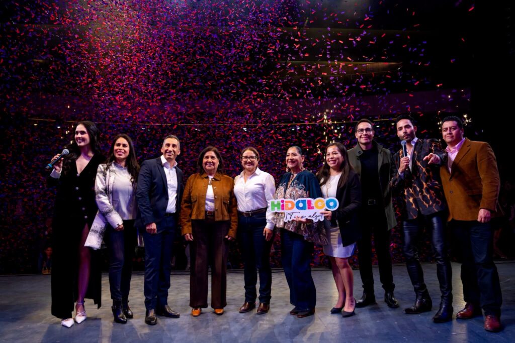Autoridades estatales y representantes de la Feria San Francisco Pachuca Hidalgo 2026 posan en el escenario durante la presentación oficial del evento, mientras cae una lluvia de confeti al finalizar el anuncio de la cartelera del Teatro del Pueblo.