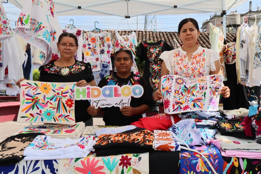 Artesanas de Hidalgo exhiben prendas y textiles bordados a mano con diseños tradicionales de Tenango de Doria durante la ceremonia de entrega de certificados por el récord Guinness de la exposición de bordados y tejidos más grande del mundo.