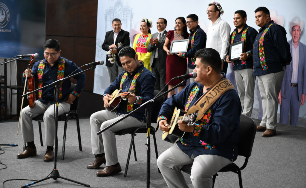 Integrantes del Trío Aurora Hidalguense interpretan huapango durante la ceremonia en la que recibieron la distinción “La Mina del Tiempo” en el Congreso de Hidalgo.