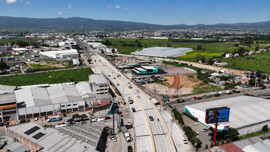 Vista aérea de un corredor vial en la zona metropolitana de Pachuca, donde se observa una de las principales vías de comunicación rodeada de áreas industriales, comerciales y de crecimiento urbano, como parte de la infraestructura que busca mejorar la movilidad en la región.