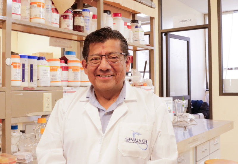 Javier Castro Rosas, investigador de la UAEH, sostiene un tubo de ensayo durante una práctica en un laboratorio de química.