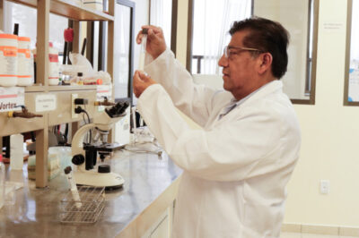 Javier Castro Rosas, investigador de la UAEH, sostiene un tubo de ensayo durante una práctica en un laboratorio de química.