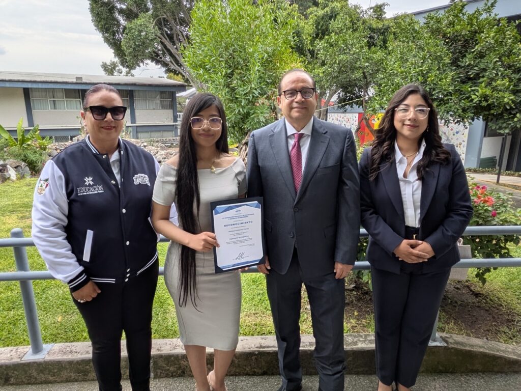Marisol Gutiérrez Torres posa con representantes educativos mientras sostiene su reconocimiento de ingeniería.