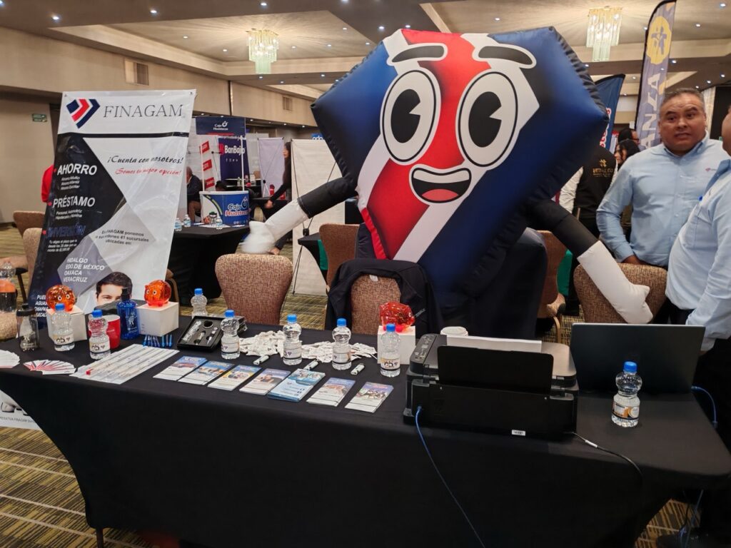 Módulo de una institución financiera con material informativo sobre ahorro, préstamos e inversión durante una exposición en Hidalgo.